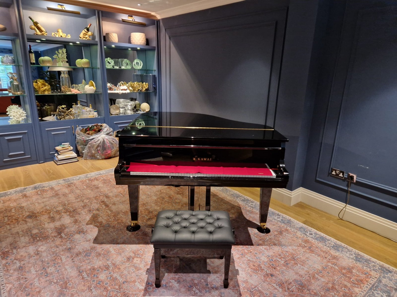 Shiny black grand piano displayed in an elegant room.